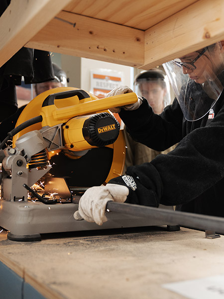 Student using a saw in shop class